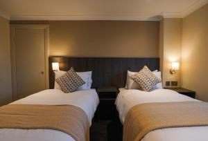 Eccleston的住宿－Park Hall Hotel,Chorley,Preston，酒店客房设有两张床和两盏灯。