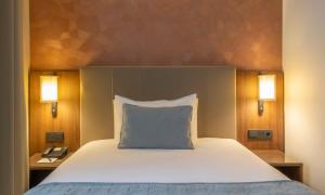 una camera da letto con un letto con un cuscino e due luci di Riu Plaza The Gresham Dublin a Dublino