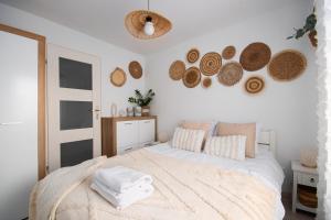 a bedroom with a white bed with baskets on the wall at Pod Trzynastką Cosy Apartment in Jelenia Góra
