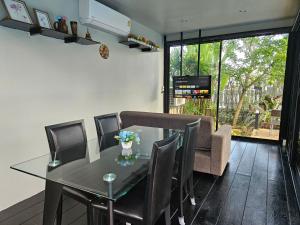 My Home Pool Villa Hatyai في هات ياي: غرفة طعام مع طاولة وكراسي زجاجية