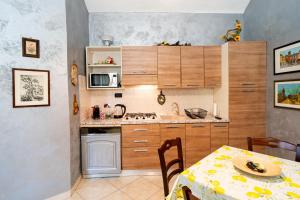 eine Küche mit Holzschränken und einem Tisch mit Tischtuch in der Unterkunft Accogliente bilocale posizione strategica in Moncalieri