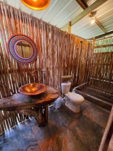 uma casa de banho com um WC e uma parede de madeira em TORTUGA BAY Eco Hotel em El Valle