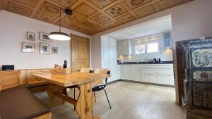 une salle à manger avec une table en bois et une cuisine dans l'établissement am Bärgbach 1.OG, à Bettmeralp