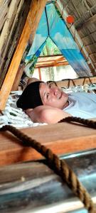 a man laying on a bed in a tent at ALCAVA Rustic Kubo Huts in Dipolog