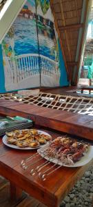 a table with two plates of food on it at ALCAVA Rustic Kubo Huts in Dipolog