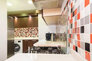 een keuken met een fornuis oven naast een wasmachine bij LUX - Opulent Island Suite 4 in Dubai