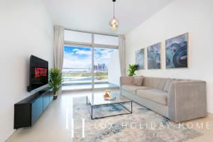 een woonkamer met een bank en een tv bij LUX - Opulent Island Suite 4 in Dubai