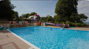 a large swimming pool with a slide in the background at 4 Devon Country, Bideford Bay Holiday Park in Bucks Mills