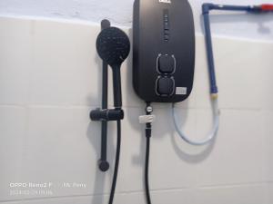 ein schwarzer Haartrockner, der an einer Wand hängt in der Unterkunft SP 5 Homestay Kuranji Kota Marudu Sabah Malaysia in Kampong Sorosob