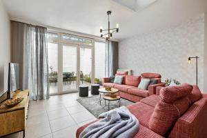 ein Wohnzimmer mit einem roten Sofa und einem Tisch in der Unterkunft Spacious house with 3 terraces in Nieuwpoort