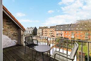 einen Balkon mit 2 Stühlen und einem Tisch auf einem Gebäude in der Unterkunft Spacious house with 3 terraces in Nieuwpoort