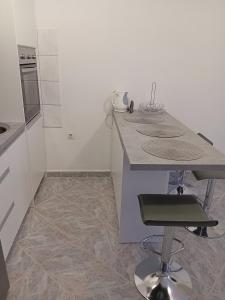 una cocina con encimera y taburete. en Apartment Novaković, en Mirce