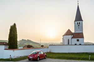 een kleine rode auto geparkeerd voor een kerk bij Mina 