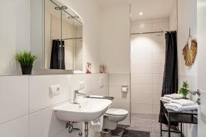 a white bathroom with a sink and a toilet at Mina 