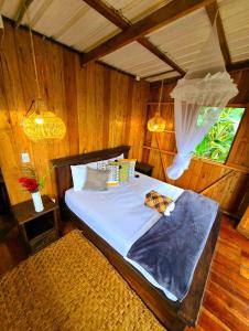 1 dormitorio con 1 cama en una habitación de madera en TORTUGA BAY Eco Hotel en El Valle