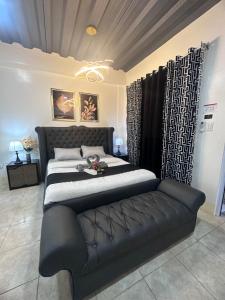 Camalaniugan的住宿－Golden Dreams Lodging Home，一间卧室配有一张大床和一张黑色沙发