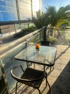 una mesa de cristal y sillas sentadas en un balcón en Golden Dreams Lodging Home, en Camalaniugan