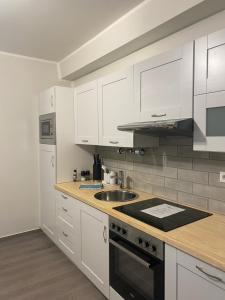 a kitchen with white cabinets and a sink and a stove at BESOTEL Erkrath- Ferienwohnungen und Apartments in Erkrath