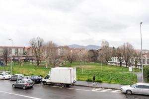 Ein weißer Truck fährt mit Autos eine Stadtstraße entlang. in der Unterkunft Accogliente bilocale posizione strategica in Moncalieri