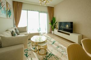 uma sala de estar com um sofá e uma televisão em Luxury Park View 2Bedroom 5pax em Dubai