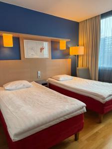 ポリにあるHotel Amadoのベッド2台と窓が備わるホテルルームです。