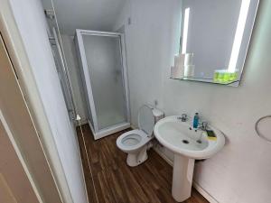 a bathroom with a toilet and a sink at Willow by Paymán Club in Royston