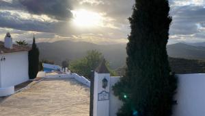 uma vista para as montanhas a partir de uma casa com o sol em El Cielo, Cortijo en el corazón de las montañas em Málaga