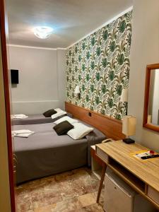 a hotel room with two beds and a mirror at Hotel Delle Rose in Mestre