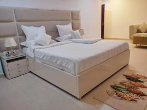 a bedroom with a large white bed and a table at Hotel Hindustan Inn in Kuchaiburi