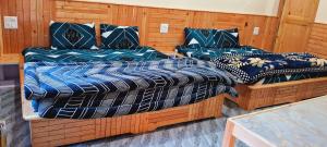 a room with three beds with blue and white at Destination Of Choj ( DOC) in Kasol