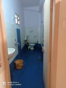 niebieska łazienka z toaletą i umywalką w obiekcie Hotel Lakshmi Residency w mieście Visakhapatnam