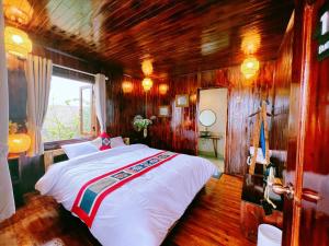 a bedroom with a bed in a room with wooden walls at Lagom Bắc Hà Farmstay in Lao Cai