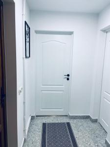 a white door in a hallway with a tile floor at Casa Cataleya in Bucşoaia