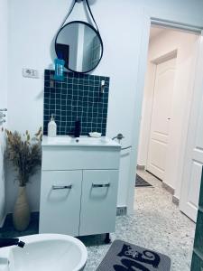 a bathroom with a white sink and a mirror at Casa Cataleya in Bucşoaia