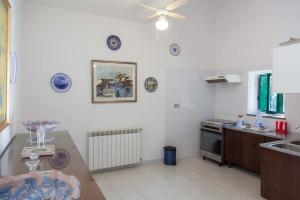 a kitchen with a table and a ceiling fan at La Casa Nel Parco in SantʼAgata di Militello