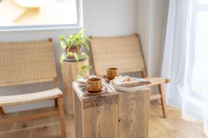 une table avec des tasses et des assiettes de nourriture dans l'établissement hotel & cafe ksnowki, à Dejimamachi