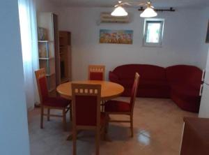 ein Wohnzimmer mit einem Tisch und einem Sofa in der Unterkunft Apartments J&M 2 in Podglavica