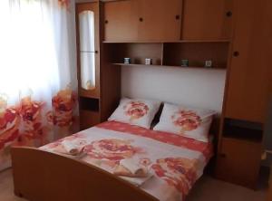 ein Schlafzimmer mit einem Bett mit Blumen darauf in der Unterkunft Apartments J&M 2 in Podglavica