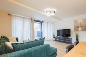 sala de estar con sofá y TV en Szemespart Residence Apartmanok By BLTN, en Balatonszemes