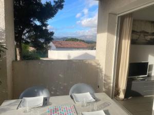 a table with two chairs and a view of the mountains at Studio 28 m2 PORTICCIO Centre in Porticcio