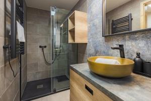 La salle de bains est pourvue d'un lavabo en bois et d'une douche. dans l'établissement Szemespart Residence Apartmanok By BLTN, à Balatonszemes