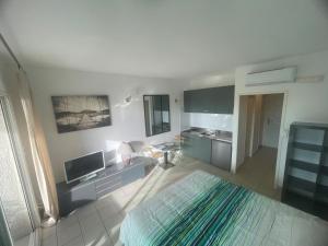 a living room with a large white room with a television at Studio 28 m2 PORTICCIO Centre in Porticcio