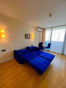 a living room with a blue couch and a table at ORBI CITY - Stylish Apartments in Batumi