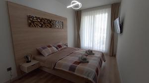 a bedroom with a bed and a large window at 19th Floor Secure Condo with Pool, Fitness, Parking Included in Price in Skopje +16 photos