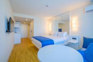 a hotel room with a bed and a blue couch at ORBI CITY - Stylish Apartments in Batumi