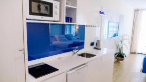 a kitchen with a sink and a couch in a room at ORBI CITY - Stylish Apartments in Batumi