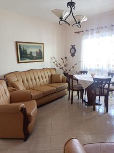 een woonkamer met een bank en een tafel bij AMEL Familiar HOUSE in Durrës