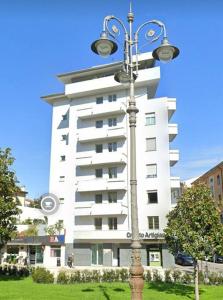 un edificio blanco con una luz de la calle delante de él en Rainbow Suite Pisa, en Pisa