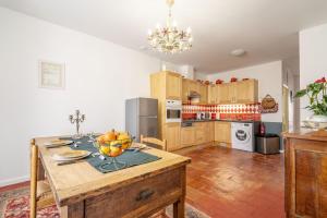 una cucina con un tavolo con una ciotola di frutta sopra di La Maison des Remparts a Saint-Jean-de-Barrou