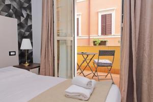 a bedroom with a bed and a chair and a window at Roma Suite Centro in Rome